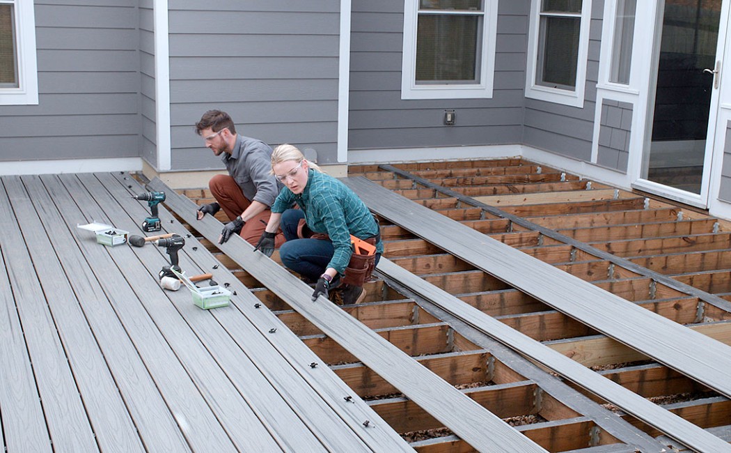 Composite Deck Installation on Backyard Patio. Deck Installation experts installing durable composite decking boards on a custom backyard patio structure.