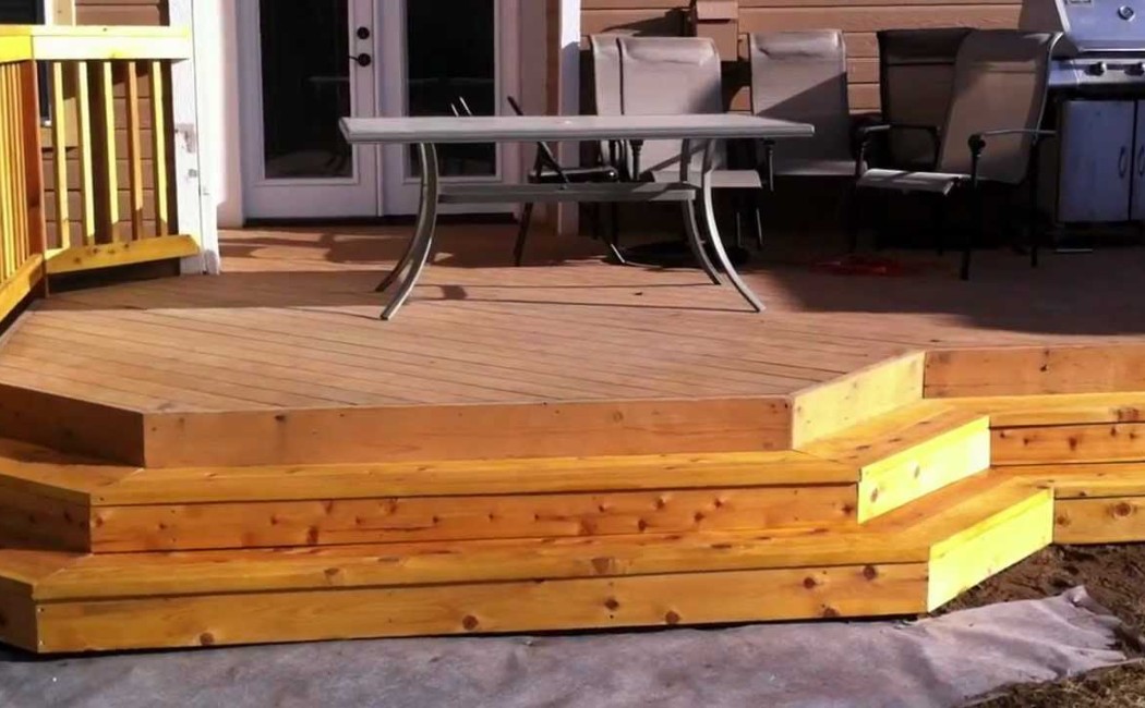 Multi-Level Deck Installation Backyard Retreat. Deck Installation featuring a custom multi-level wooden deck with wide steps, outdoor seating, and a backyard entertainment area.
