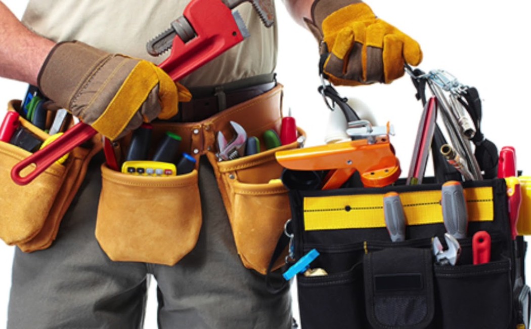 Handyman services professional carrying a tool belt and toolbox filled with repair and maintenance tools, ready for home improvement work.