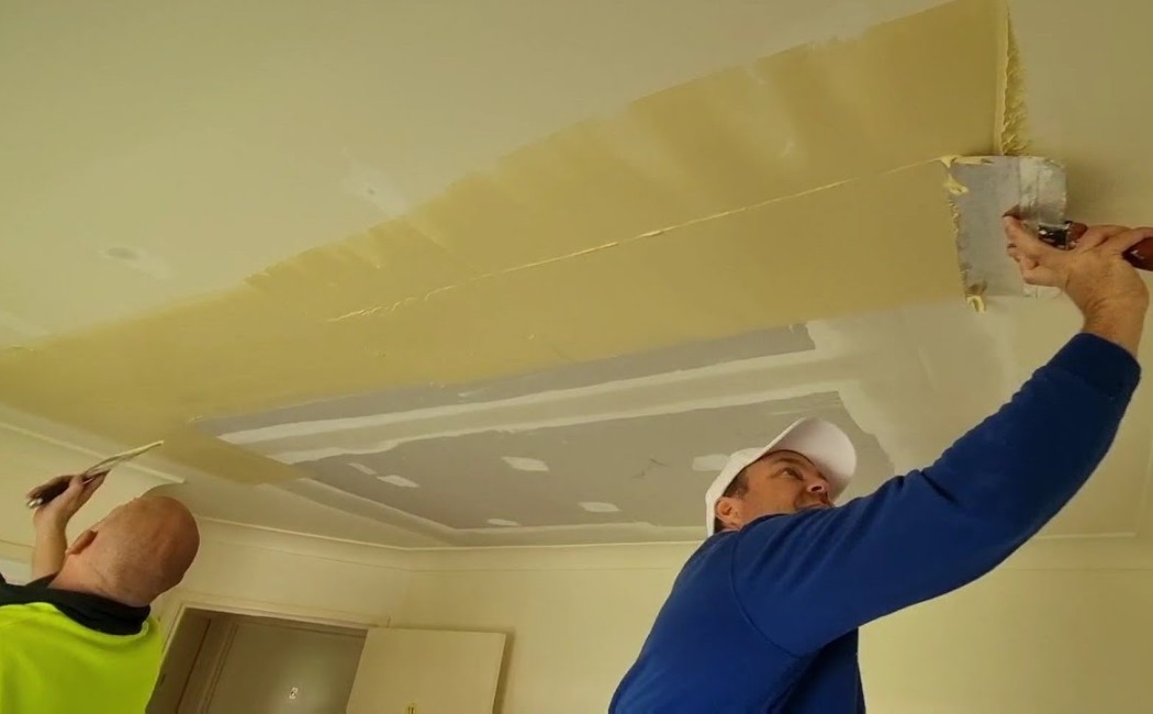 Drywall Repair Ceiling Finishing Experts. Drywall Repair experts applying joint compound and finishing a ceiling drywall surface during an interior renovation project.